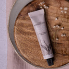 Dublin Herbalists Lemongrass and Bergamot Hand Cream 30ml - tube lying on a wooden board with dried flowers