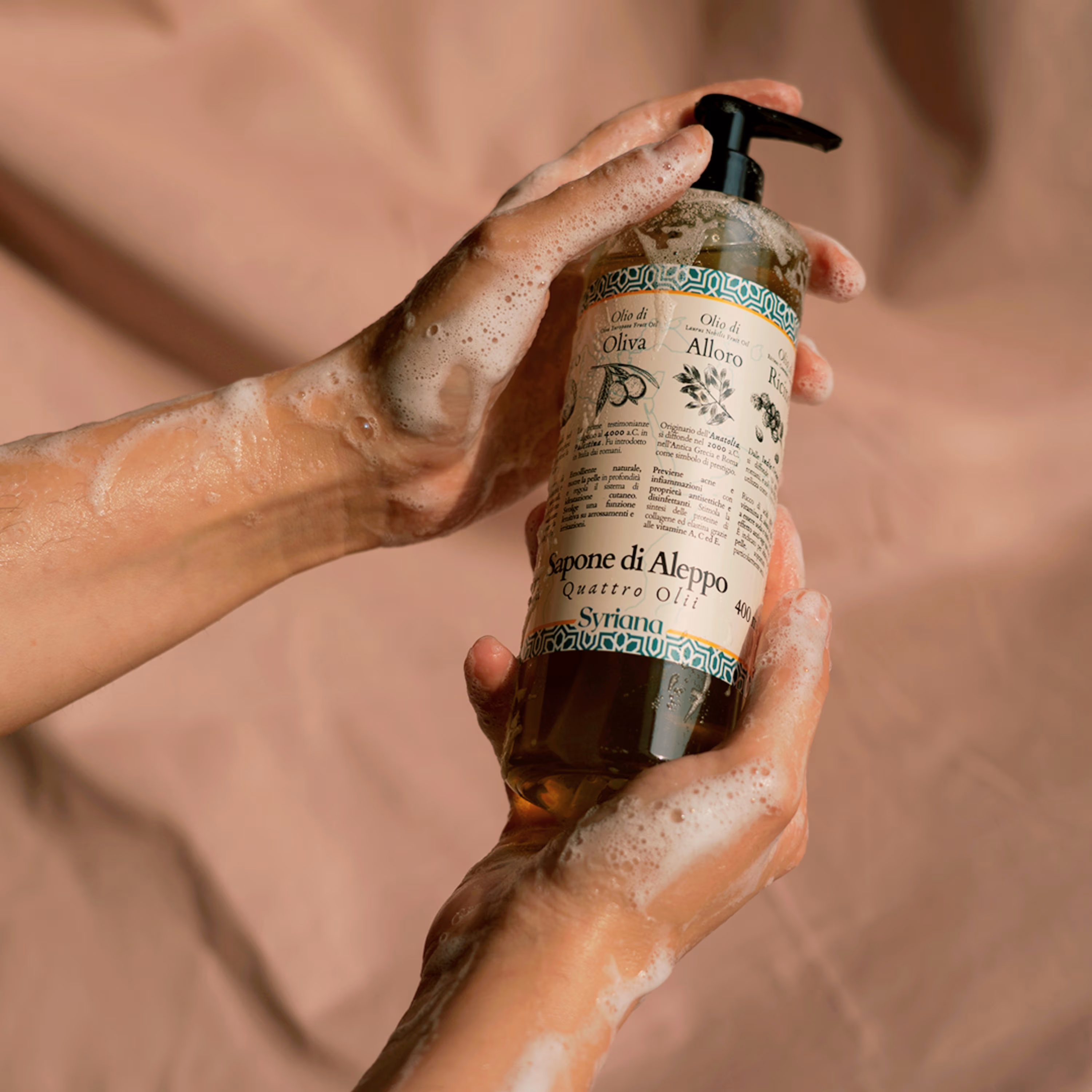 Syriana Quattro Olii Liquid Aleppo Soap 400ml - Hands washing with Liquid Aleppo Soap foam against a soft fabric background